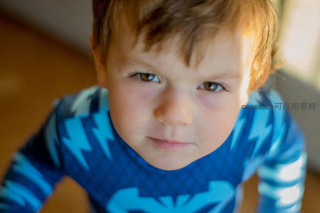 蓝衣男孩抬头直视镜头，眼神清澈