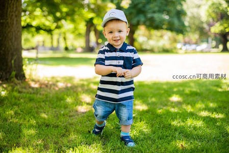 阳光草坪上微笑的可爱小男孩