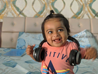 戴着耳机在床上开心舞动的萌趣宝宝