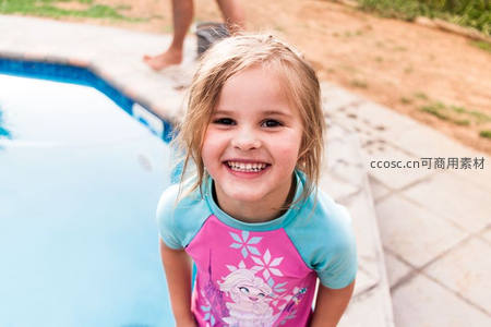 泳池边身穿公主泳衣的甜美女孩微笑