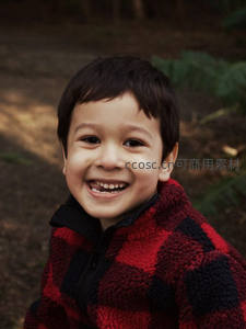 红黑格子衫男孩林间绽放灿烂笑