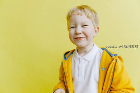 穿黄色外套的男孩对着镜头微笑