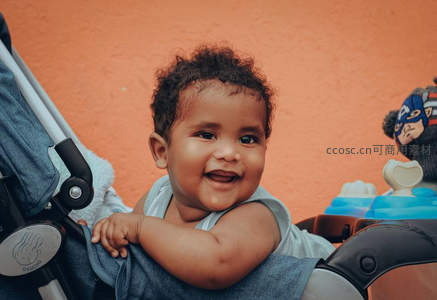 婴儿在推车里开心大笑的温馨画面