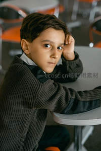 教室里男孩托腮沉思，眼神专注