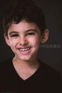卷发男孩微笑露出洁白牙齿