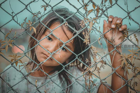 女孩透过铁丝网凝视镜头