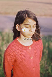 红衣少女颊边雏菊，田野微风轻拂发梢
