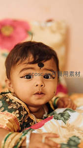 印度婴儿身着传统服饰，额点朱砂眼神清澈