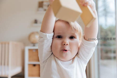 宝宝举着积木专注玩耍瞬间