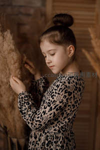 豹纹裙女孩轻抚干草束