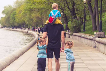 父亲肩扛儿子牵手双胞胎女儿