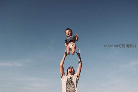 父亲高举婴儿蓝天之下