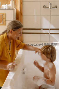 母亲为孩子在浴缸中洗澡的温馨瞬间