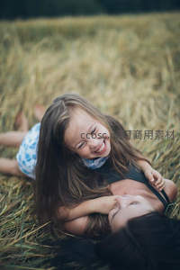 金黄麦田里母女嬉戏大笑的幸福画面