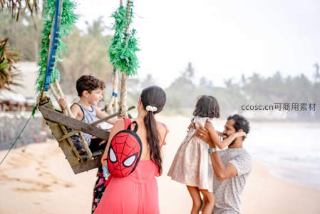 全家海滩度假荡秋千享天伦之乐