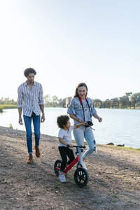 湖畔漫步：孩子骑平衡车父母相伴左右