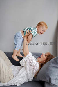 客厅嬉戏：母亲高举宝宝共享欢乐