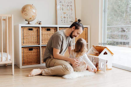 父女共玩木制娃娃屋温馨时刻