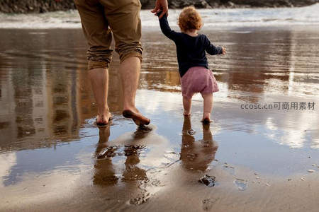 沙滩上父女赤足踏浪嬉戏
