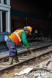 铁路工人用锤子敲击轨道进行维护