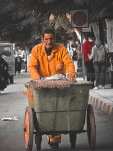 街头清洁工推着垃圾车辛勤工作