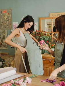 花艺师在工作台前为顾客量身定制围裙