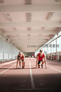 男女运动员室内跑道准备起跑
