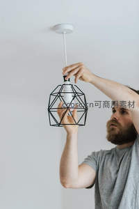 男子正在安装现代几何造型吊灯