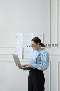 职场女性站立使用笔记本电脑办公