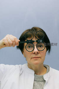 眼科医生手持试镜架进行视力测试