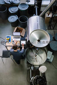 咖啡师操控大型烘焙机专注制作精品咖啡
