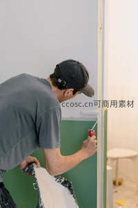 工人专注粉刷墙面细节特写