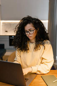 卷发女孩专注笔记本电脑工作