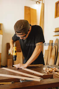 木匠戴护目镜专注钻孔