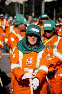 橙色工装队列中的女性工作者