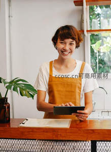 微笑店员手持平板站在柜台后服务