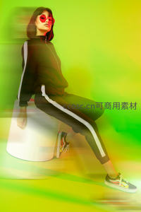 霓虹光影中的时尚女郎动感坐姿