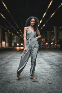 隧道灯光下微笑的灰裤装女