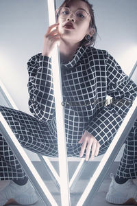 戴眼镜女子倚靠发光灯管摆拍