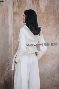 白衣背影靠土墙，简约设计显气质