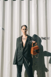 光影下的时尚女性与棕色手袋