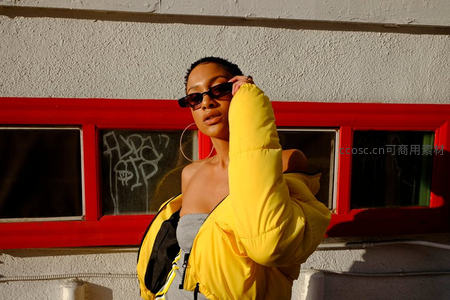 街头时尚：黄色羽绒服与红色窗框的撞色