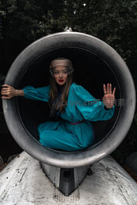 蓝裙女子置身巨大金属管道中