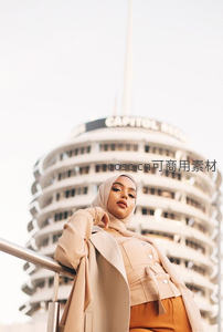 城市地标前优雅头巾女子