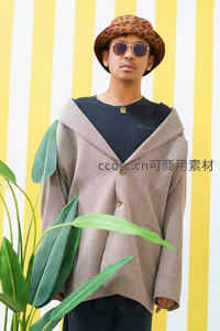 条纹墙前潮男，豹纹帽与格纹外套的混搭