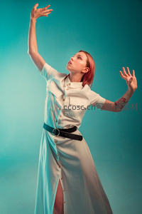 蓝调背景下伸展的优雅舞者