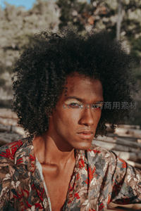 卷发男子特写，自然光下眼神深邃