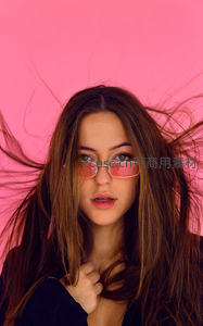 粉墙前戴墨镜的飘逸长发女