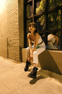 夜色砖墙边白裤少女坐姿