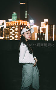 夜幕霓虹下戴帽少女侧影